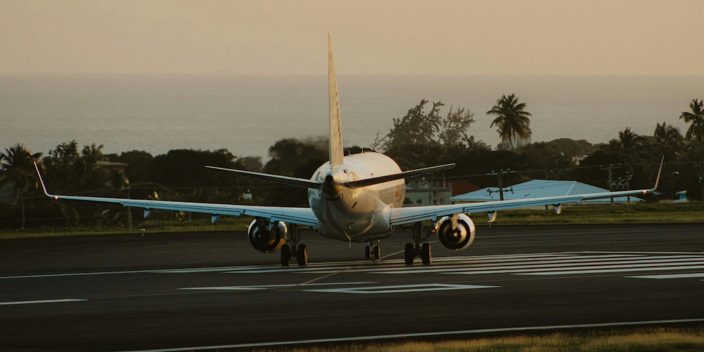 Plane about to takeoff from a tropical island with the ocean in the background