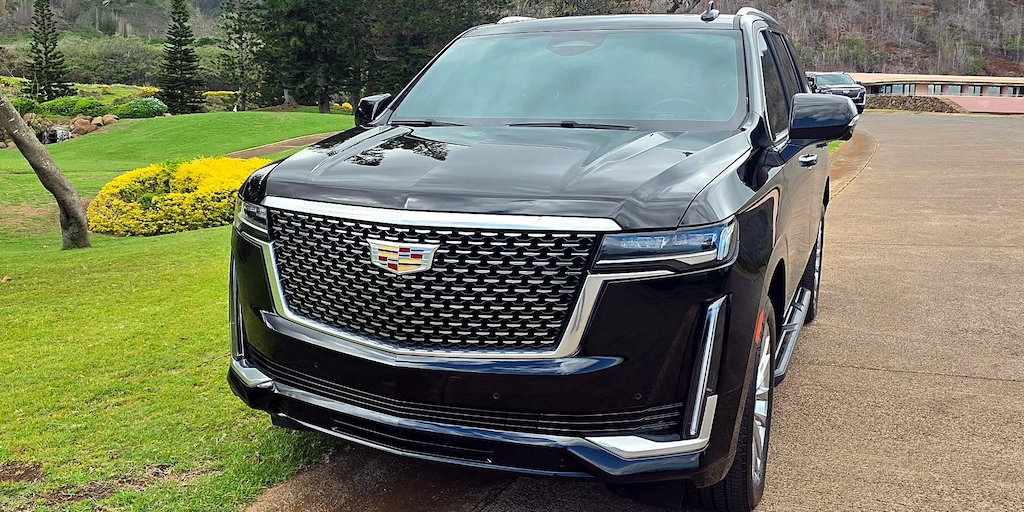 Front three-quarter view of the Maui Luxe Cadillac Escalade parked on a Maui driveway.