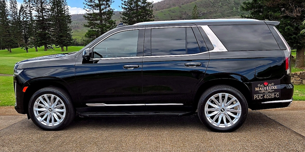 Full side profile of the Maui Luxe Cadillac Escalade parked on a Maui driveway.