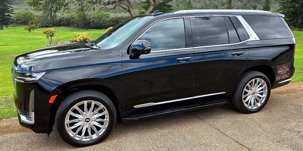 Side profile of the Maui Luxe Cadillac Escalade with Maui landscape behind it.